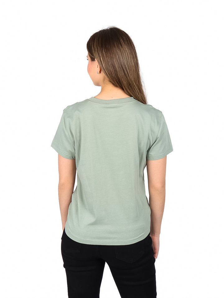 Mujer vistiendo playera color verde claro con detalle de nudo en la parte frontal.