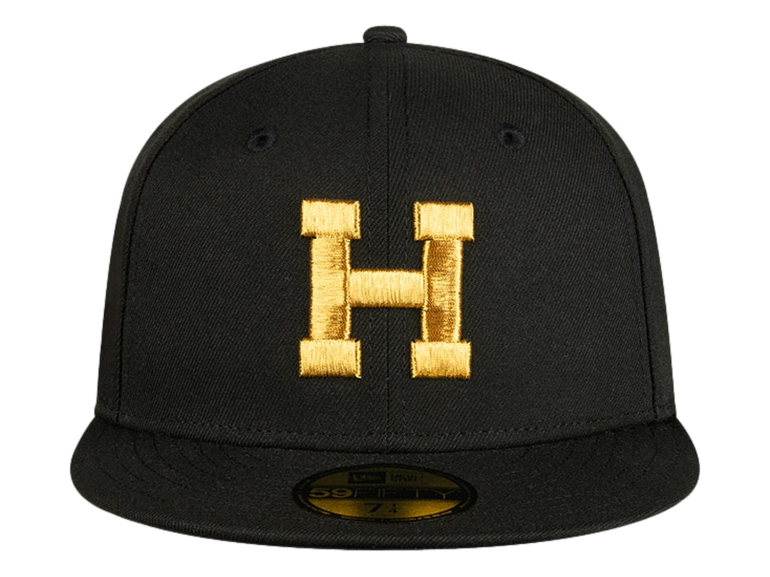 Gorra de béisbol New Era color negro con letra H bordada en dorado en el frente y visera plana.