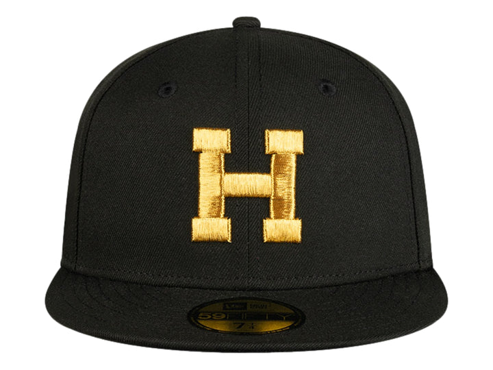 Gorra de béisbol New Era color negro con letra H bordada en dorado en el frente y visera plana.