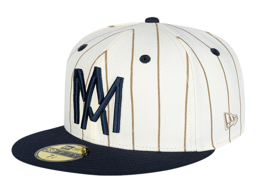 Gorra New Era blanca con rayas cafés, visera azul marino y letras MM bordadas en el frente.