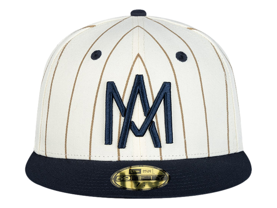 Gorra New Era blanca con rayas cafés, visera azul marino y letras MM bordadas en el frente.