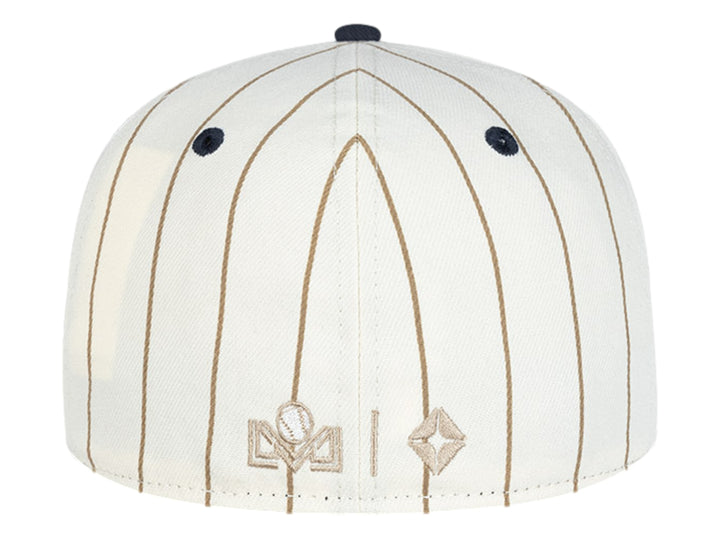Gorra New Era blanca con rayas cafés, visera azul marino y letras MM bordadas en el frente.