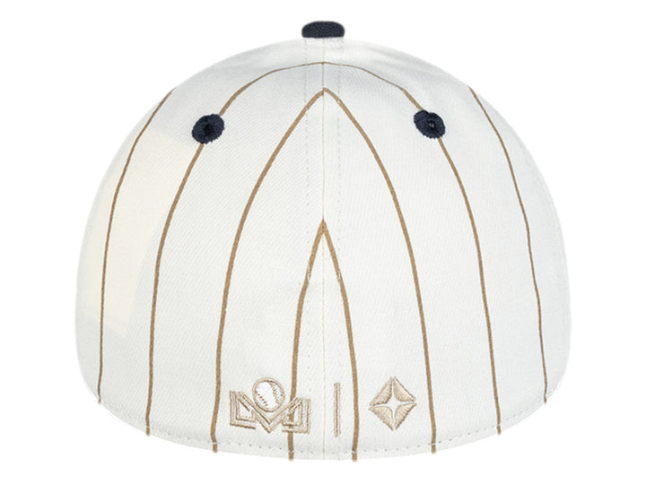 Gorra New Era blanca con rayas doradas, visera azul marino y logotipo bordado en el frente.