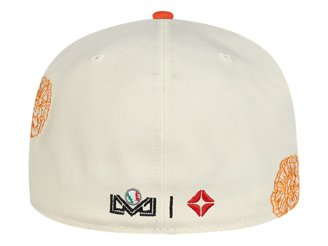 Gorra New Era blanca con visera naranja y detalles de parches y bordados decorativos.