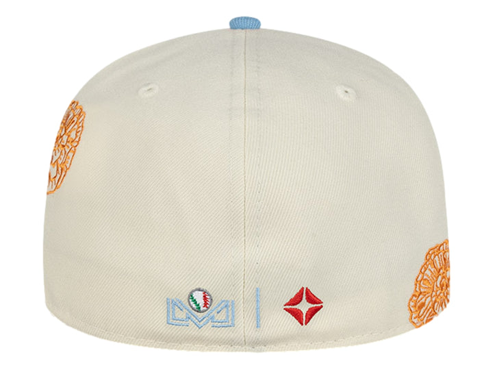 Gorra New Era blanca con visera azul, detalles bordados en naranja y azul, y un pequeño parche rosa.