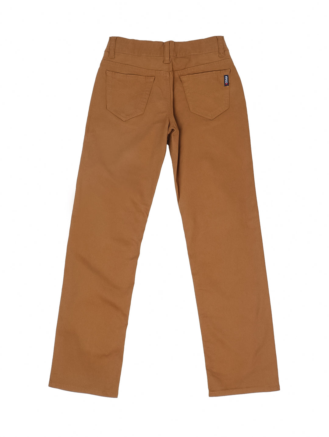 Niño modelando un pantalón casual color tabaco con camiseta blanca y tenis beige.