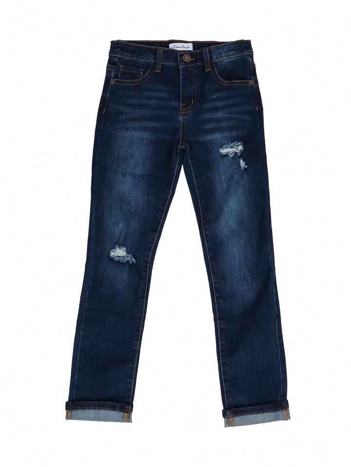 Pantalones jeans para niño en color azul denim medio con detalles de desgaste y roturas decorativas.
