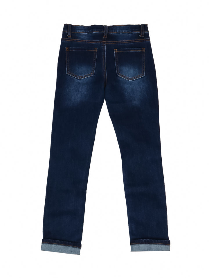 Pantalones jeans para niño en color azul denim medio con detalles de desgaste y roturas decorativas.