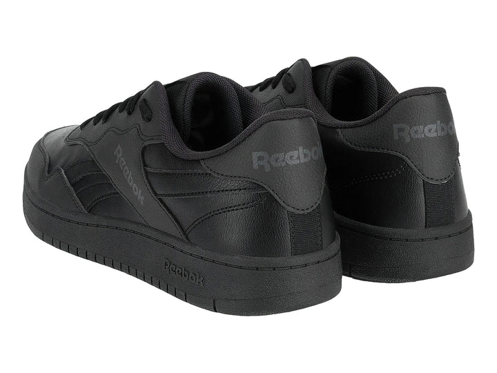 Tenis Reebok color negro con suela plana y cordones, vista lateral.