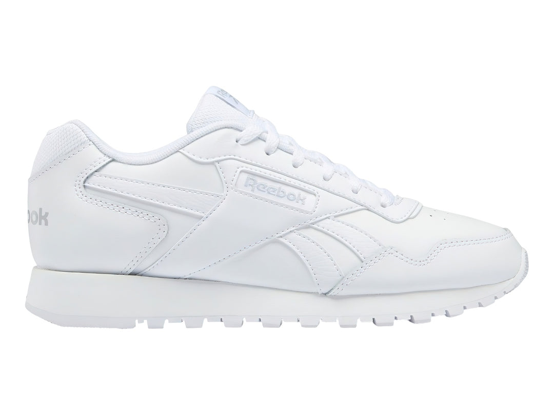 Tenis deportivos Reebok de color blanco, corte bajo, con cordones y suela blanca.