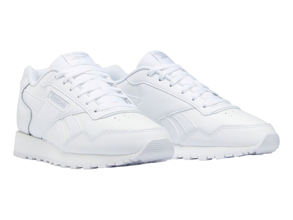 Tenis deportivos Reebok de color blanco, corte bajo, con cordones y suela blanca.