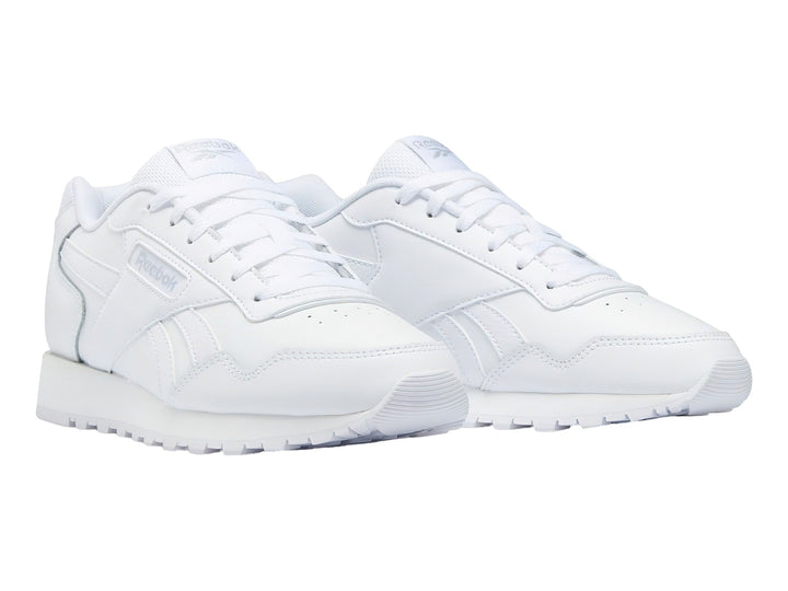 Tenis deportivos Reebok de color blanco, corte bajo, con cordones y suela blanca.
