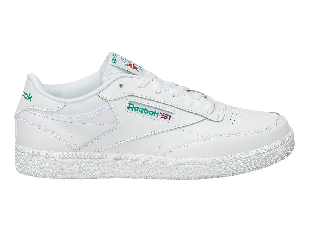 Tenis Reebok Club C blancos con detalles verdes y suela blanca.