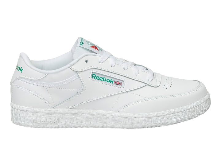 Tenis Reebok Club C blancos con detalles verdes y suela blanca.