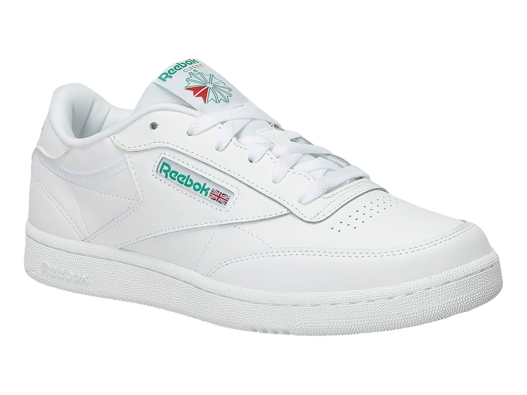 Tenis Reebok Club C blancos con detalles verdes y suela blanca.