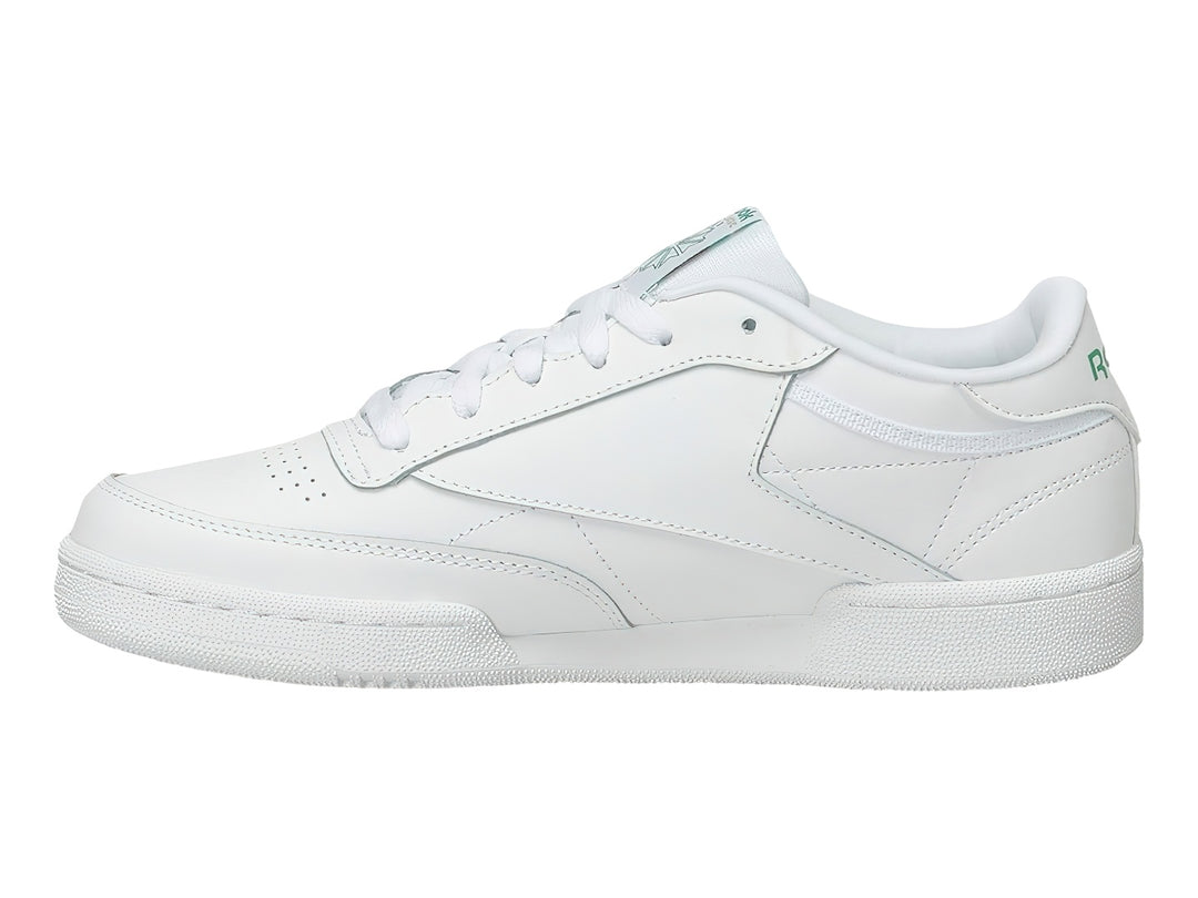 Tenis Reebok Club C blancos con detalles verdes y suela blanca.