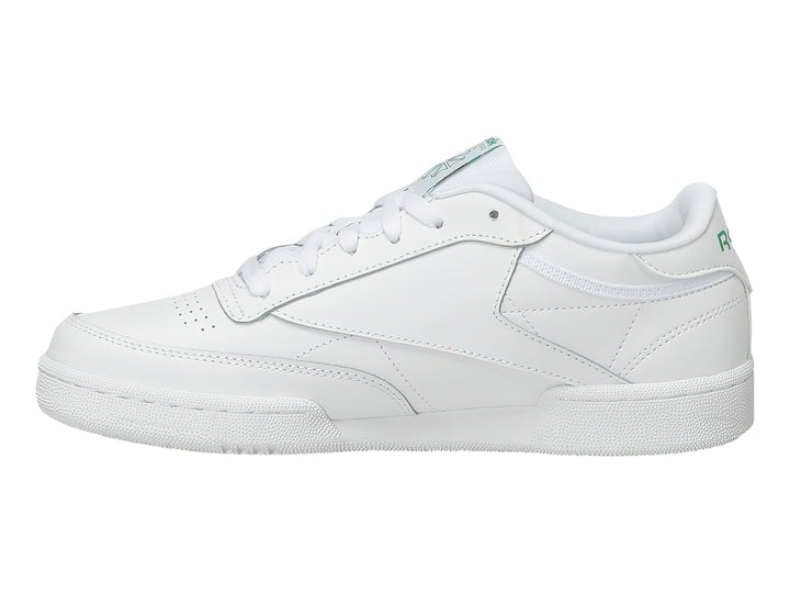 Tenis Reebok Club C blancos con detalles verdes y suela blanca.