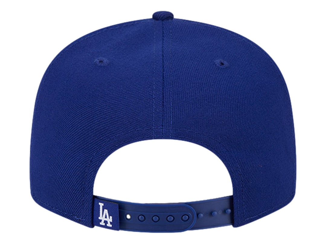 Gorra New Era azul con visera plana y diseño gráfico bordado en blanco y azul en el frente.