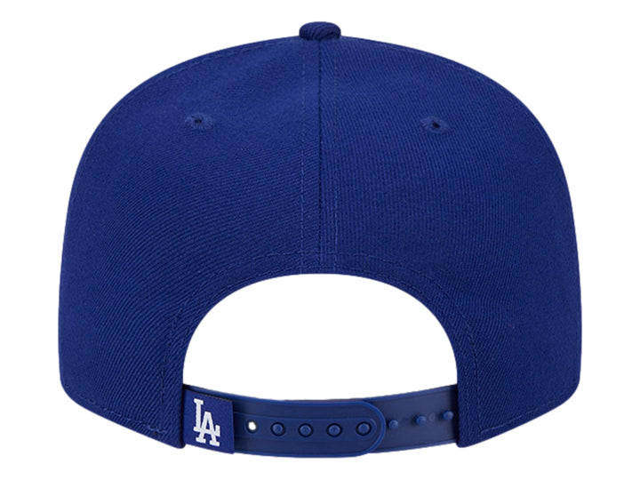 Gorra New Era azul con visera plana y diseño gráfico bordado en blanco y azul en el frente.