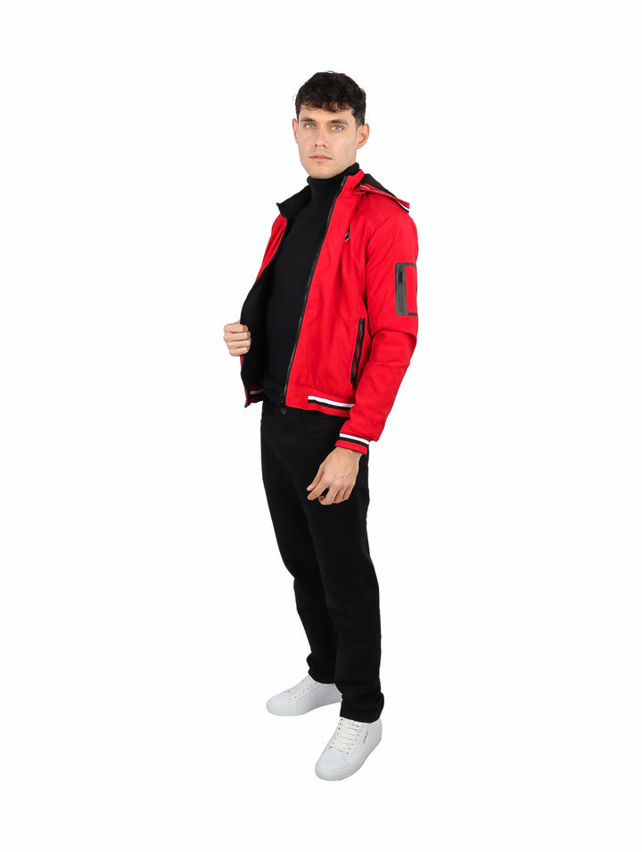 Hombre vistiendo chamarra reversible color rojo con detalles en negro y capucha.