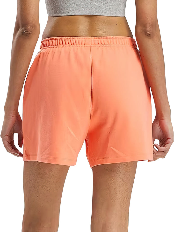 Shorts deportivos color coral de la marca Reebok con cintura elástica.