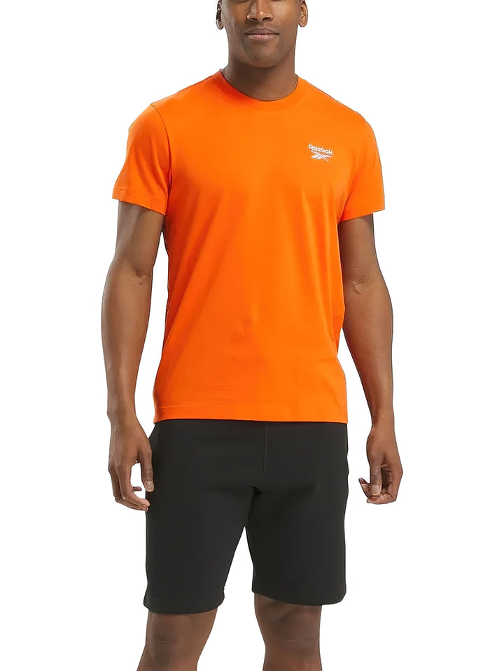 Camiseta deportiva Reebok de color naranja con logotipo blanco pequeño en el pecho.