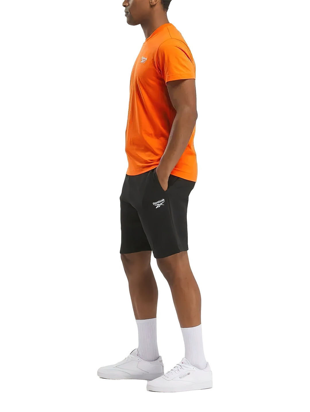 Camiseta deportiva Reebok de color naranja con logotipo blanco pequeño en el pecho.