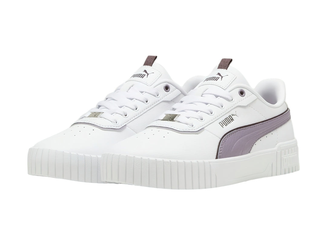Tenis PUMA blancos con franja morada pálida y suela de plataforma blanca.