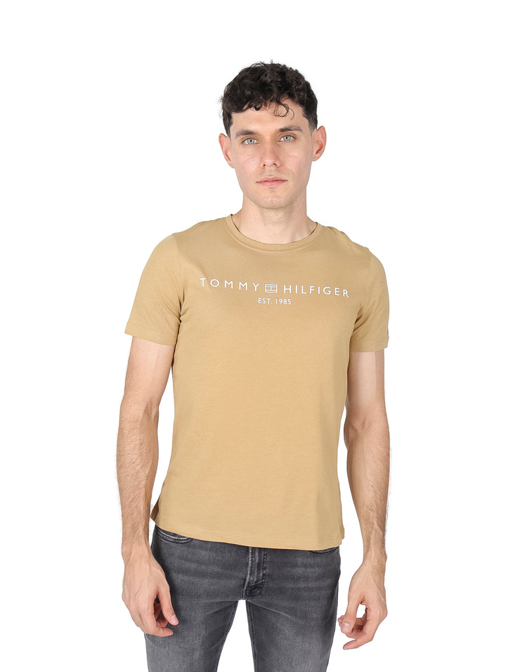 Hombre vistiendo una camiseta de color khaki con el logo de Tommy Hilfiger en el pecho.