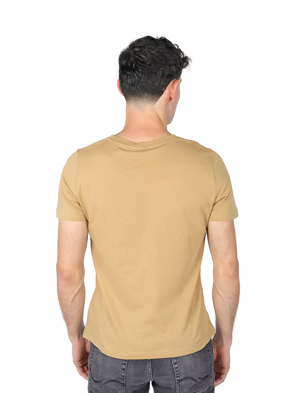 Hombre vistiendo una camiseta de color khaki con el logo de Tommy Hilfiger en el pecho.