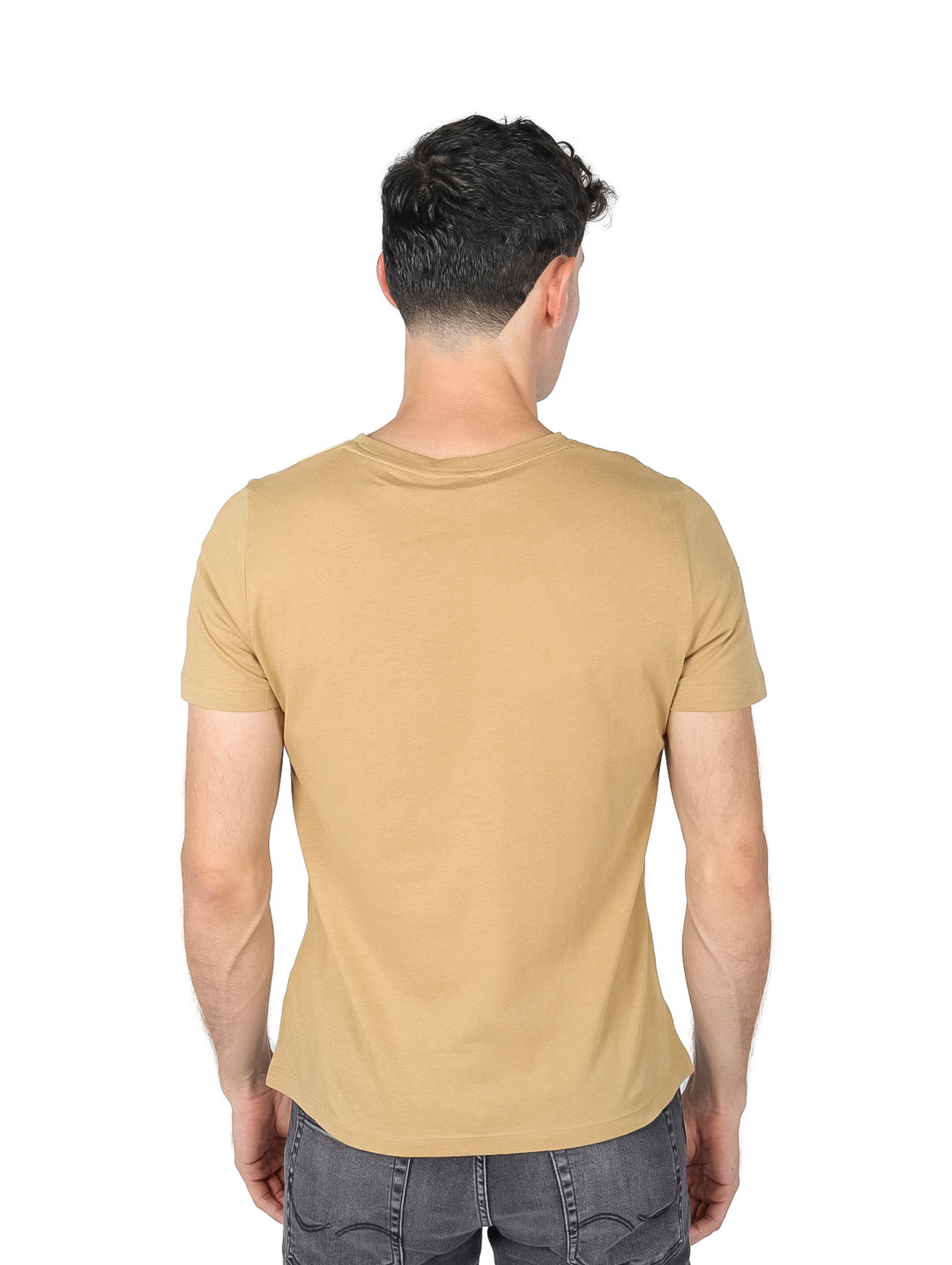 Hombre vistiendo una camiseta de color khaki con el logo de Tommy Hilfiger en el pecho.