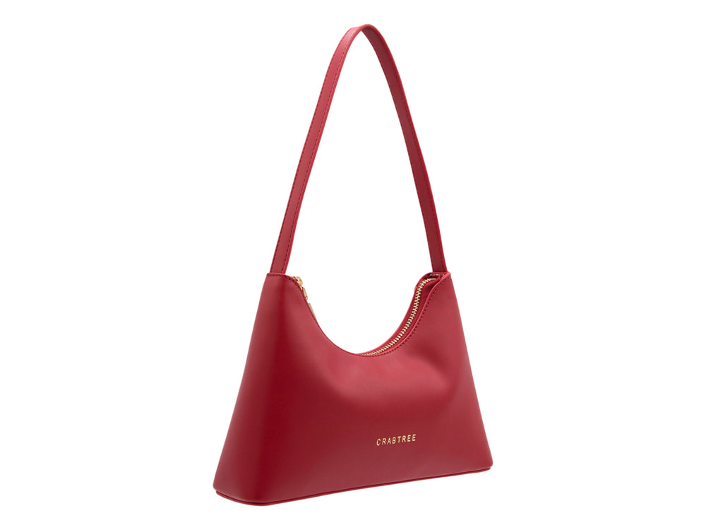 Bolso de hombro color rojo marca Crabtree con diseño curvo, asa larga y acabado liso.