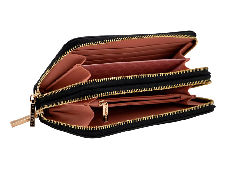 Bolso estilo cartera color negro brillante con cierre y logotipo metálico en tono dorado.