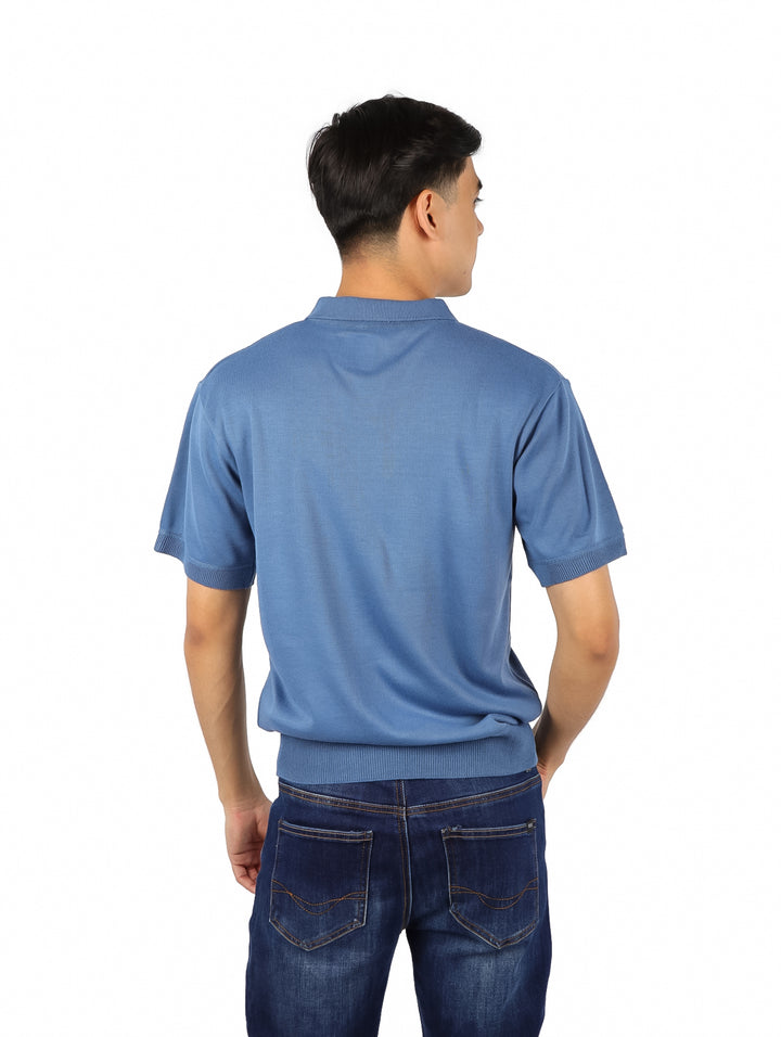 Hombre vistiendo una playera polo de color azul con cuello y manga corta.