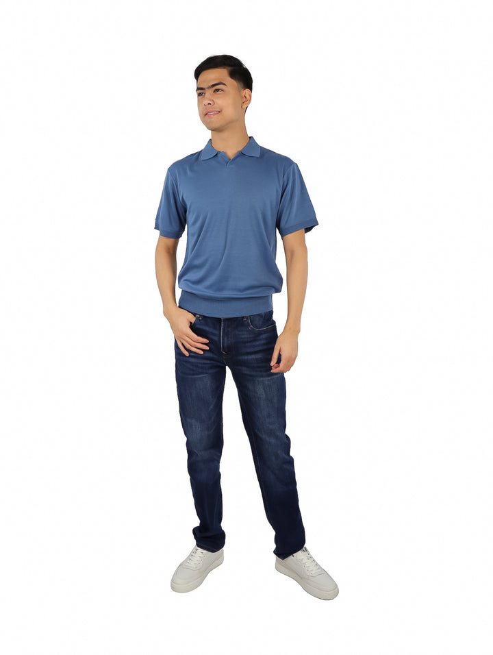 Hombre vistiendo una playera polo de color azul con cuello y manga corta.