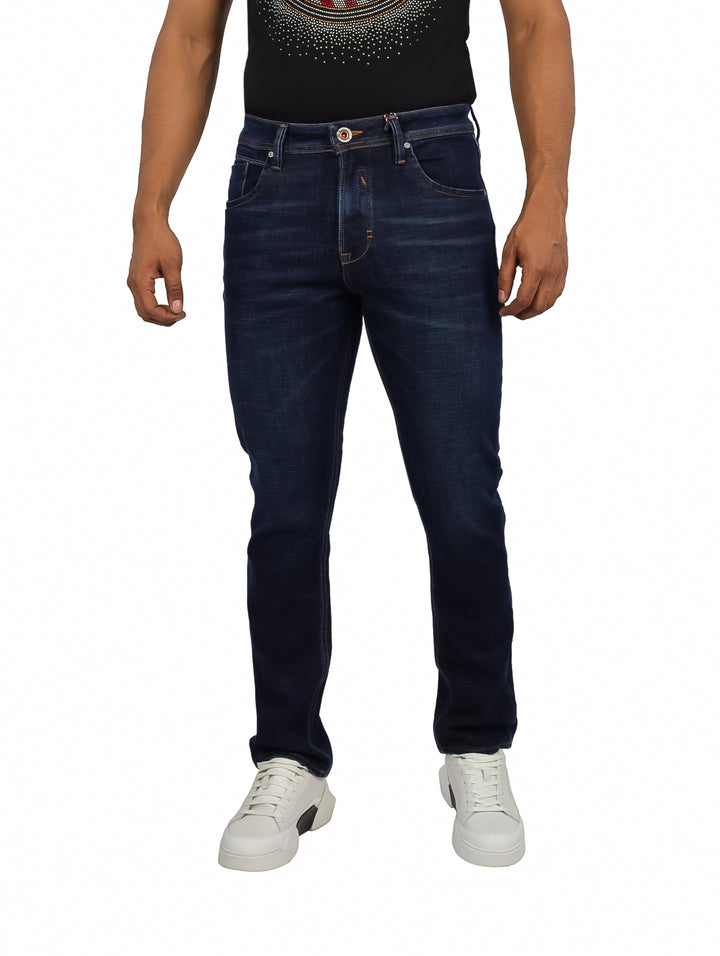 Hombre vistiendo jeans color dark indigo de corte ajustado y tenis blancos.