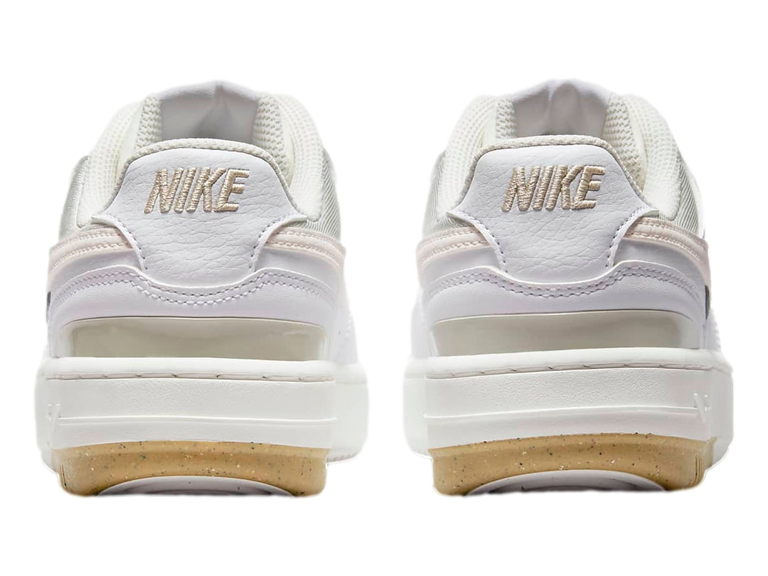 Tenis Nike Gamma Force color blanco y beige con suela de goma marrón, vista lateral.