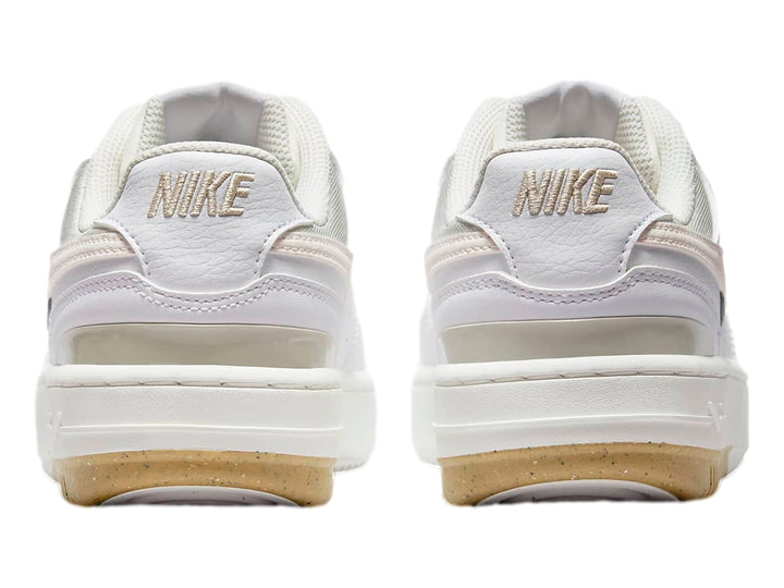 Tenis Nike Gamma Force color blanco y beige con suela de goma marrón, vista lateral.