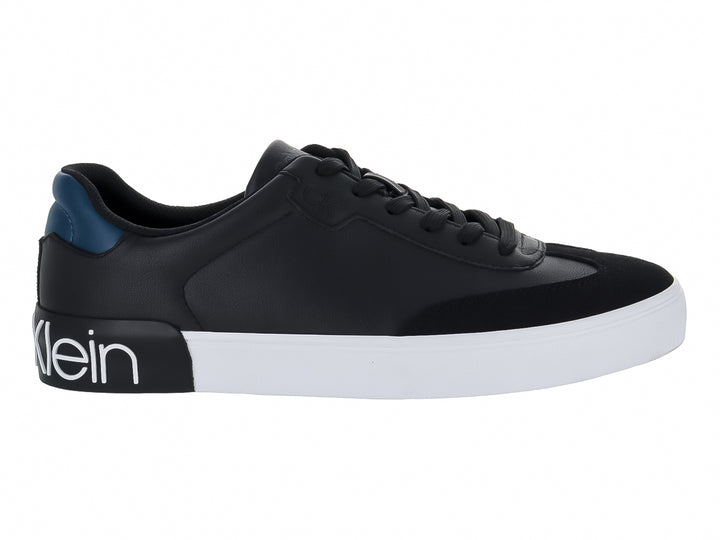 Tenis negros Calvin Klein con suela blanca y detalle azul en el talón.