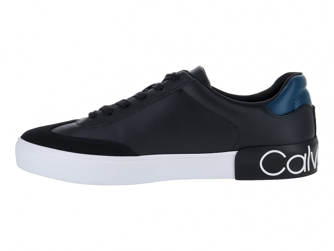 Tenis negros Calvin Klein con suela blanca y detalle azul en el talón.