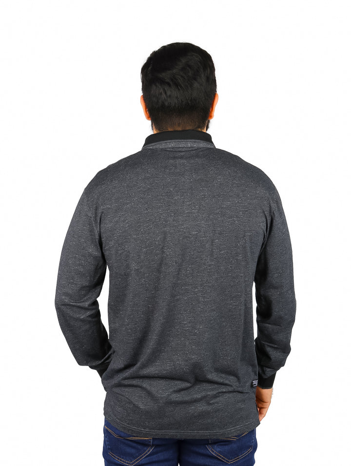 Hombre vistiendo playera polo de manga larga en color gris oscuro con cuello y puños negros.