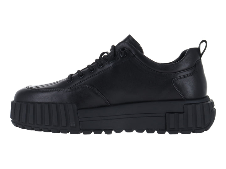 Tenis negros de cuero con suela gruesa y plataforma.