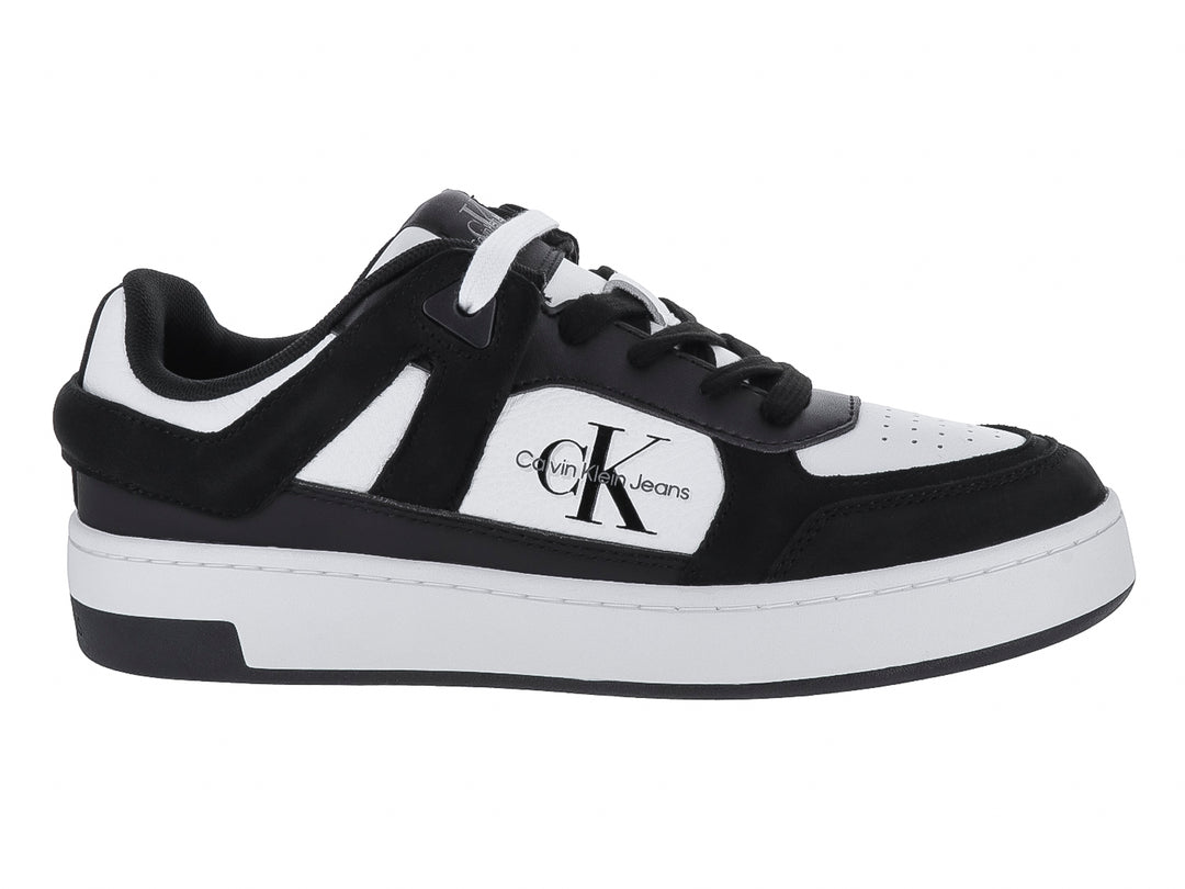 Tenis Calvin Klein de corte bajo en colores blanco y negro con logotipo CK lateral.
