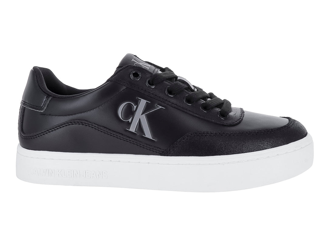 Tenis Calvin Klein negros de cuero con suela blanca y logotipo CK en el lateral.