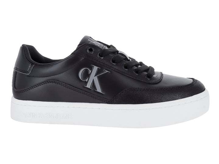 Tenis Calvin Klein negros de cuero con suela blanca y logotipo CK en el lateral.
