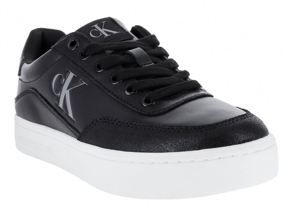 Tenis Calvin Klein negros de cuero con suela blanca y logotipo CK en el lateral.