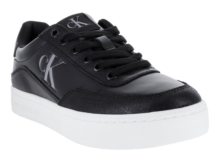Tenis Calvin Klein negros de cuero con suela blanca y logotipo CK en el lateral.