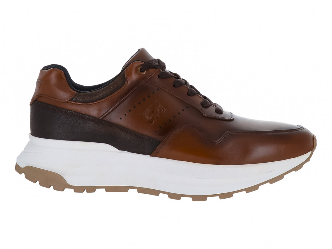 Zapato deportivo Kenneth Cole de piel color nuez con suela blanca y detalles en marrón oscuro.