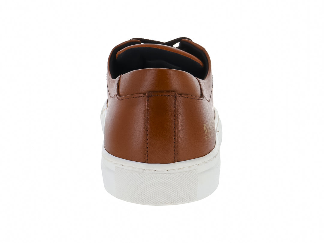 Tenis Kenneth Cole Reaction de piel color nuez con suela blanca y cordones marrón oscuro.