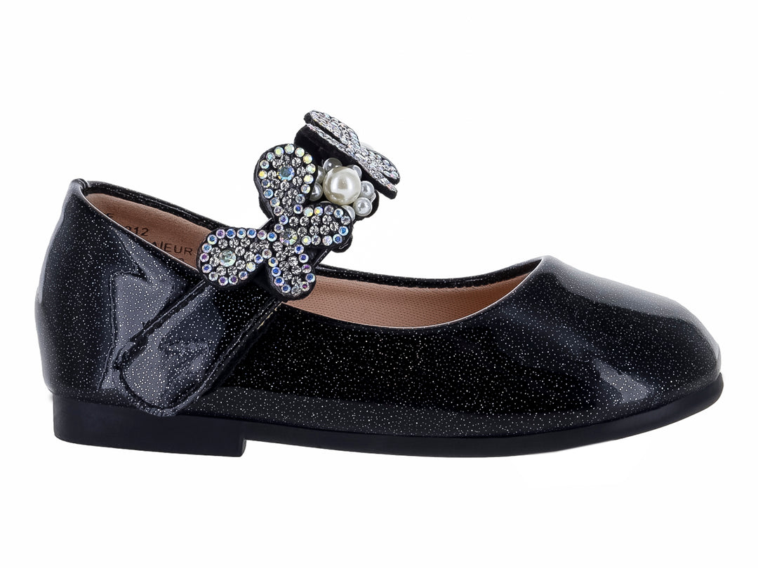 Zapato plano negro brillante para niña con moño decorado con pedrería y una perla central.